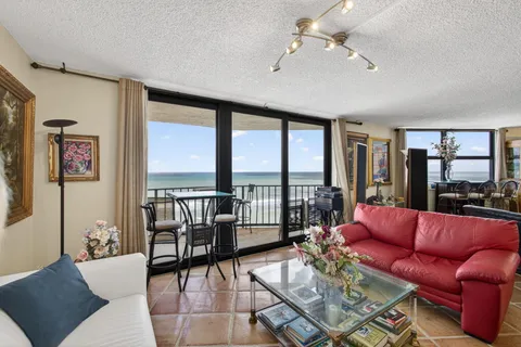 a living room with furniture and a floor to ceiling window
