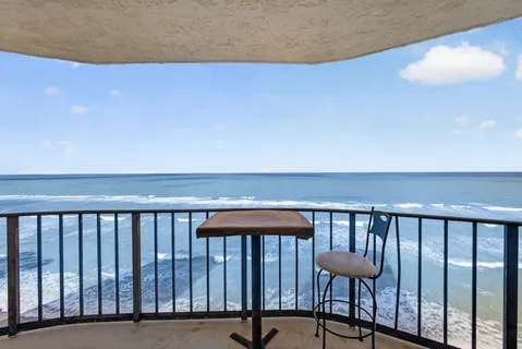 a balcony with a table and chairs