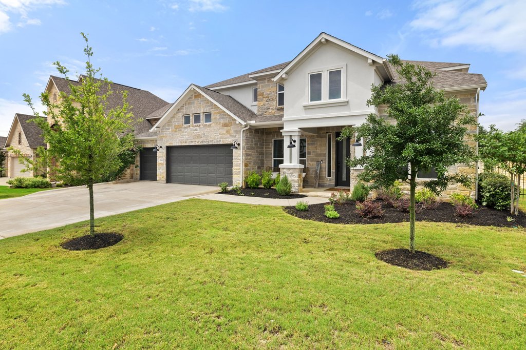365 Pear Tree Lane Austin, TX 78737 - Photo 1 of 39 a front view of a house with a yard and garage