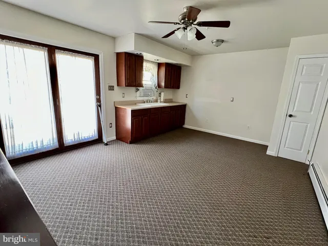 a living room with stainless steel appliances kitchen island granite countertop furniture and a flat screen tv
