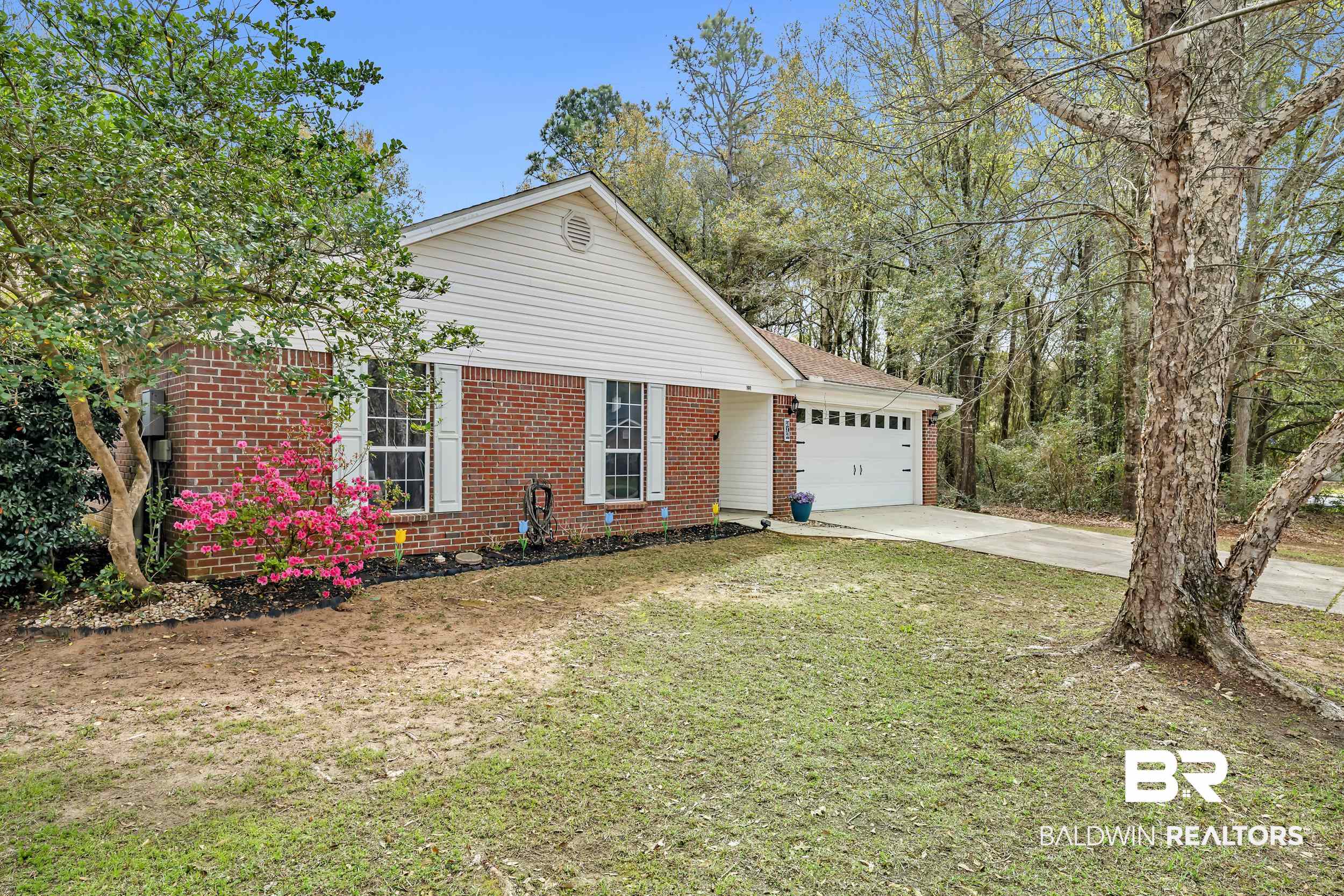 191 Robbins Boulevard Daphne, AL 36526 - Photo 2 of 24 View of front of house with brick siding, concrete driveway, an attached garage, and a front yard