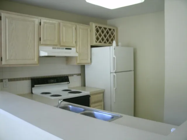 a kitchen with refrigerator and cabinets
