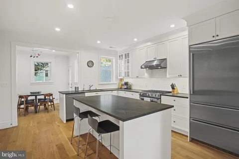 a kitchen with stainless steel appliances granite countertop a sink a stove and a refrigerator
