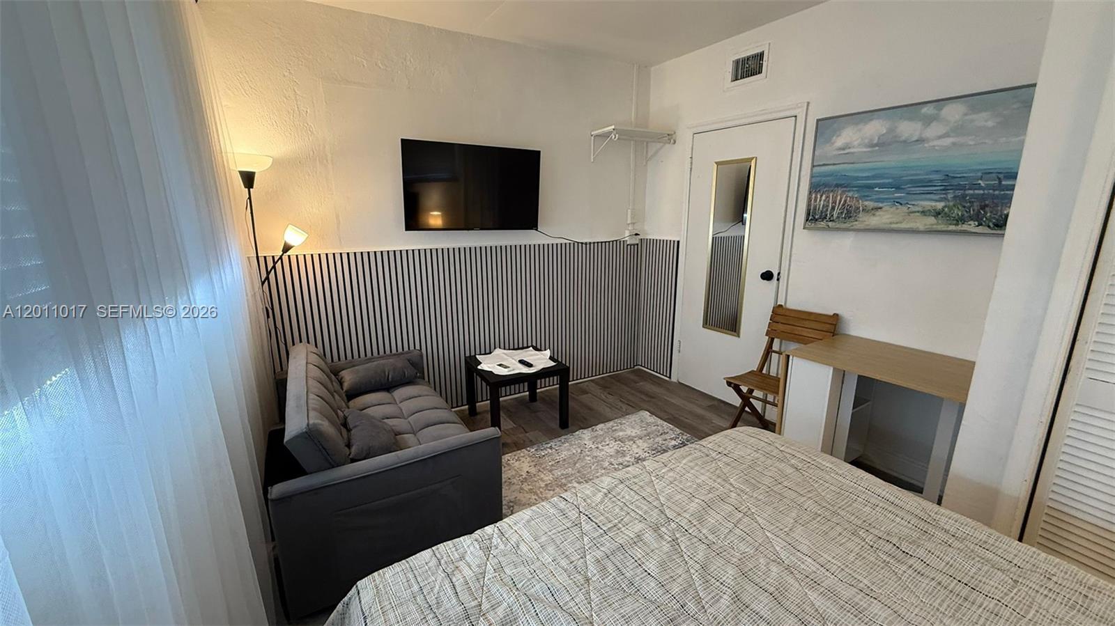115 Southeast 2nd Street, Unit 2 Dania Beach, FL 33004 - Photo 1 of 11 a bedroom with a bed and a television