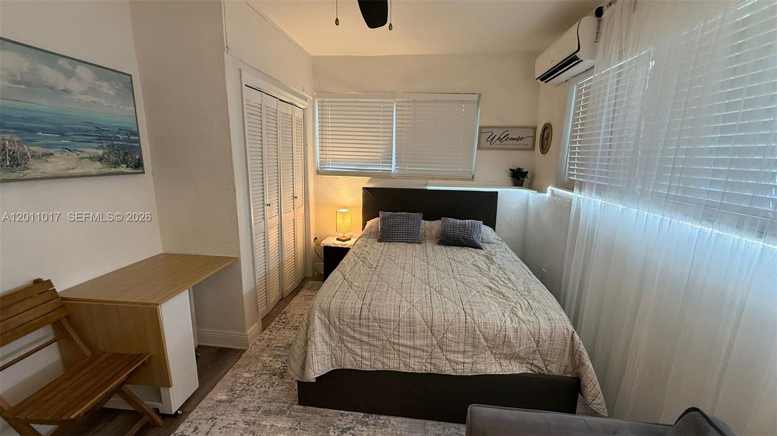 115 Southeast 2nd Street, Unit 2 Dania Beach, FL 33004 - Photo 2 of 11 a bedroom with a bed and wooden floor