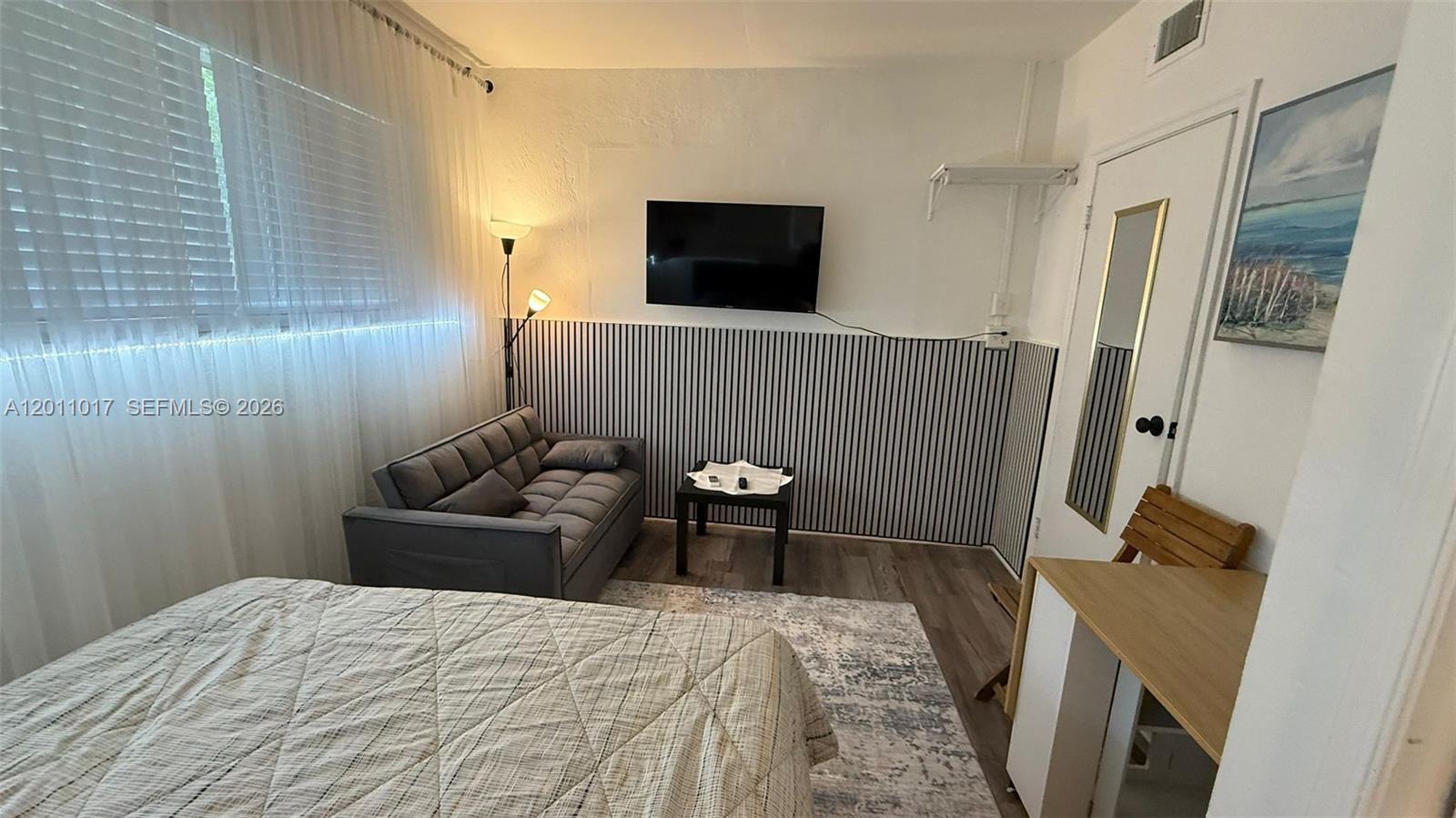 115 Southeast 2nd Street, Unit 2 Dania Beach, FL 33004 - Photo 3 of 11 a bedroom with a bed and a flat screen tv