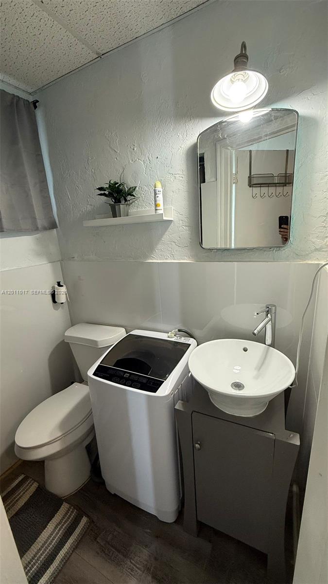 115 Southeast 2nd Street, Unit 2 Dania Beach, FL 33004 - Photo 4 of 11 a bathroom with a toilet sink and mirror