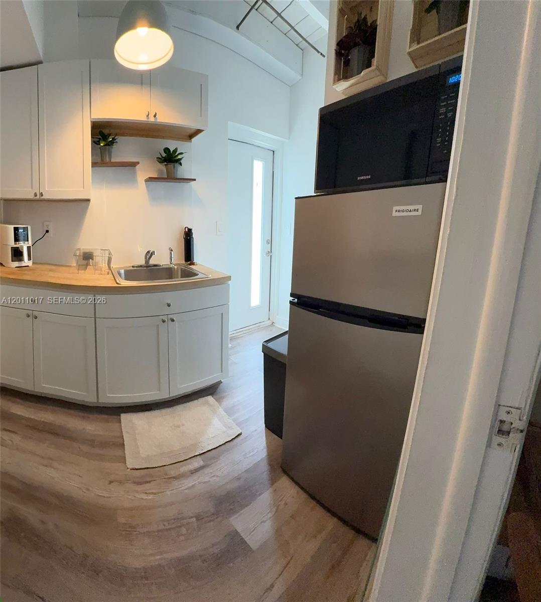 115 Southeast 2nd Street, Unit 2 Dania Beach, FL 33004 - Photo 7 of 11 a kitchen with a refrigerator and a sink