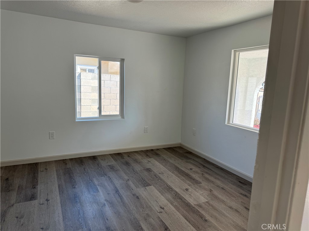 5263 35th Street Jurupa Valley, CA 92509 - Photo 12 of 19 an empty room with wooden floor and windows