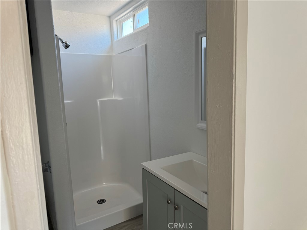 5263 35th Street Jurupa Valley, CA 92509 - Photo 15 of 19 a bathroom with a granite countertop sink a mirror and shower