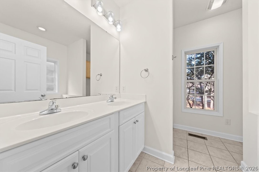60 Spring Lake Drive Pinehurst, NC 28374 - Photo 18 of 42 a bathroom with a double vanity sink and a mirror