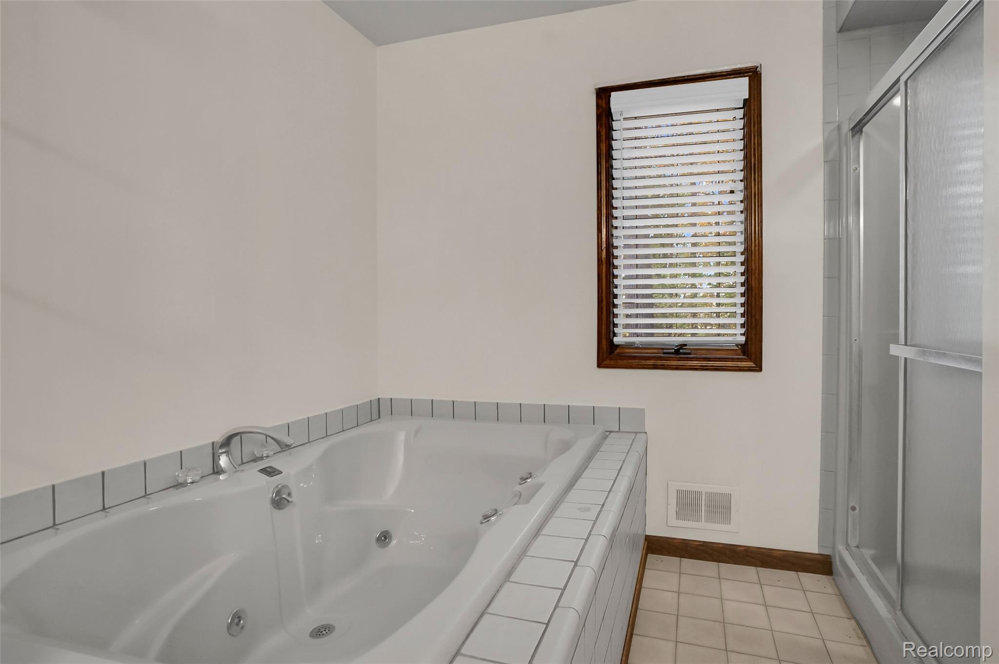 1431 East Commerce Road Commerce Township, MI 48382 - Photo 19 of 27 Bathroom with light tile patterned floors, a tub with jets, and a shower stall
