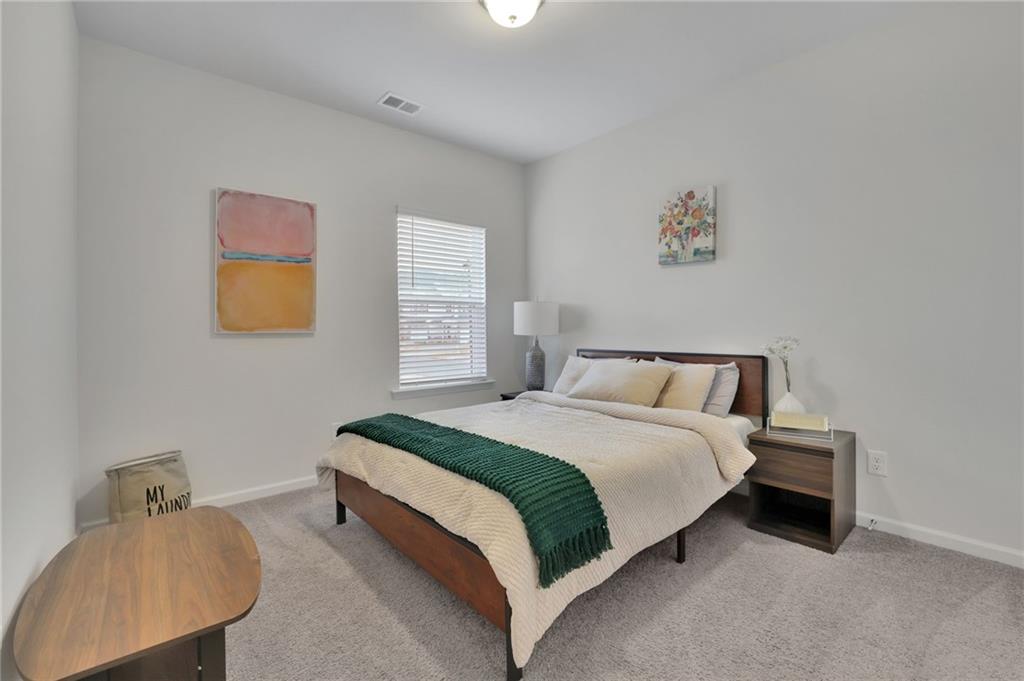 803 Dundee Way Cartersville, GA 30121 - Photo 17 of 37 a spacious bedroom with a bed and painting on the wall