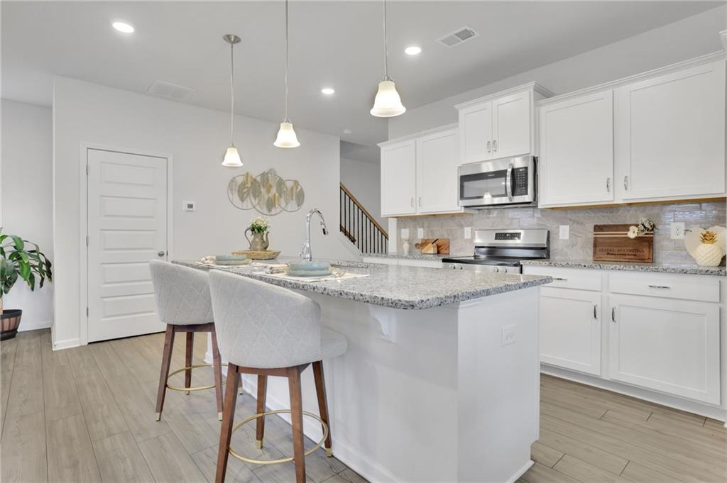 803 Dundee Way Cartersville, GA 30121 - Photo 8 of 37 a kitchen with kitchen island granite countertop a sink and a refrigerator