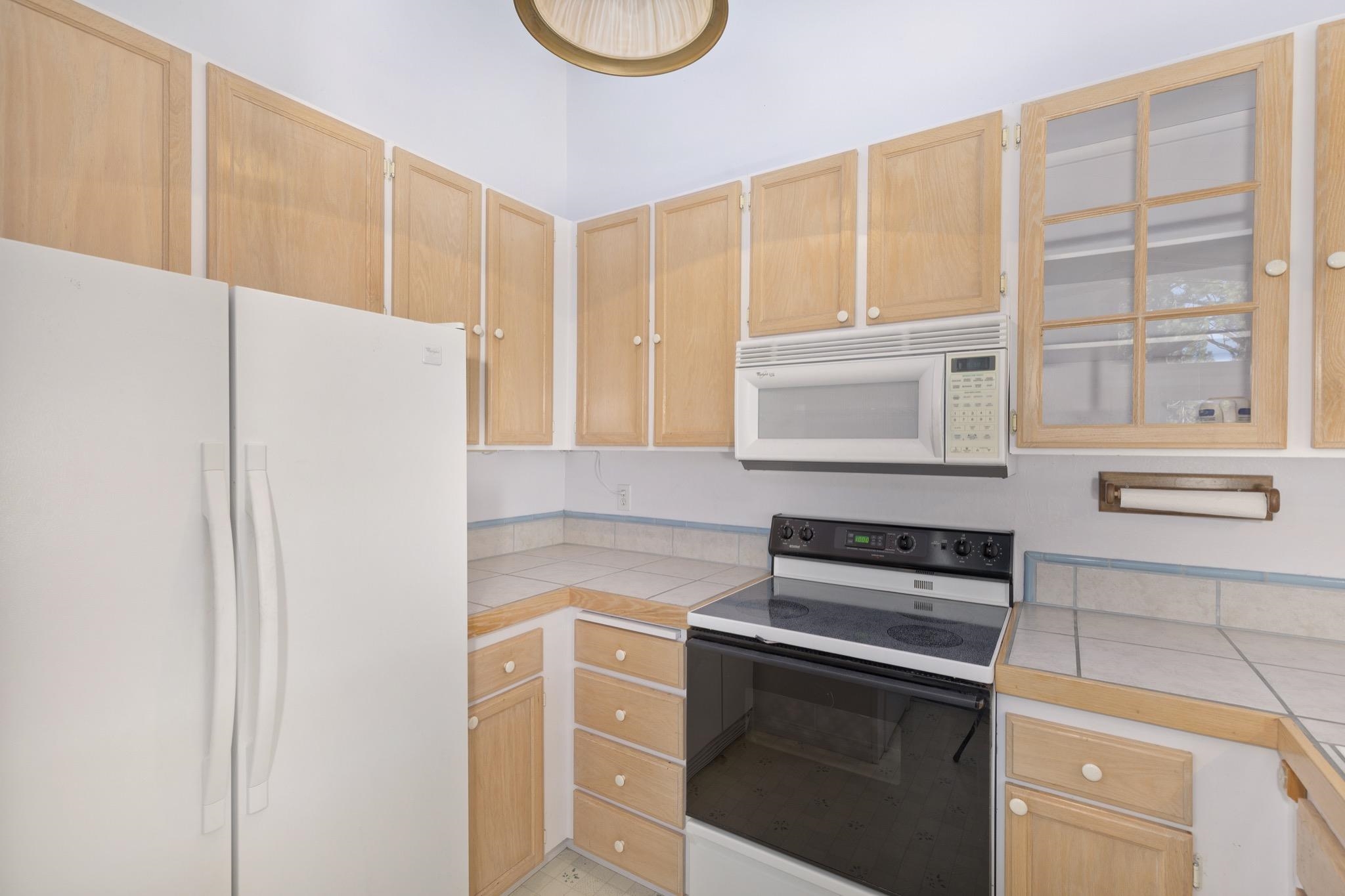 3251 Chateau Road, Unit 40 Mammoth Lakes, CA 93546 - Photo 6 of 31 Kitchen featuring white appliances, light wood finish cabinets, and tile counters