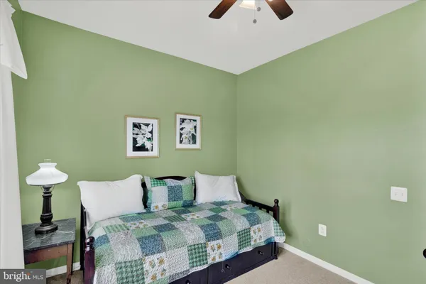 a bedroom with a bed and a lamp on dresser