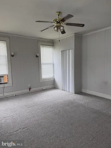 a view of a livingroom with a ceiling fan and window