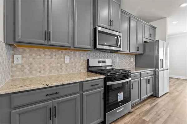a kitchen with stainless steel appliances granite countertop white cabinets granite counter tops and a stove