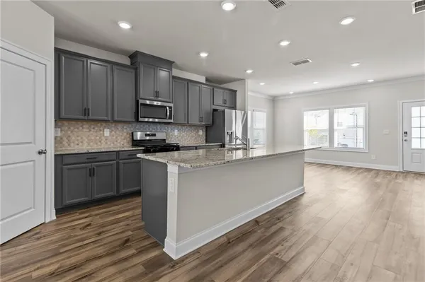 a kitchen with stainless steel appliances granite countertop a stove a sink and a refrigerator