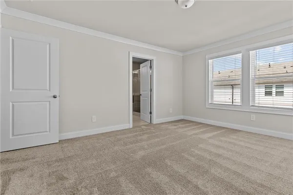 a view of an empty room with closet and mirror
