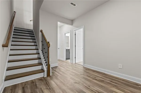 a view of a hallway with wooden floor and staircase