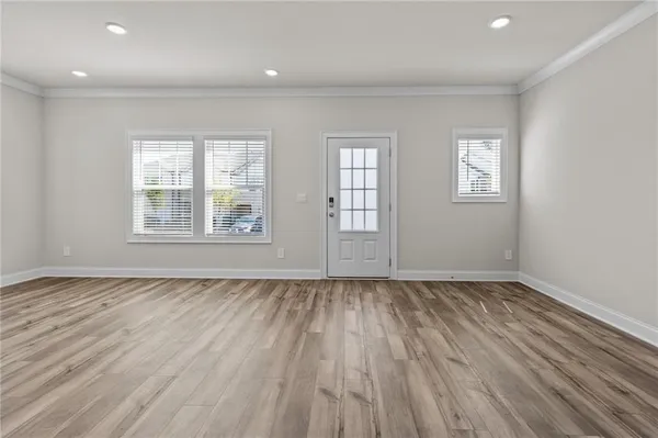 an empty room with wooden floor and windows