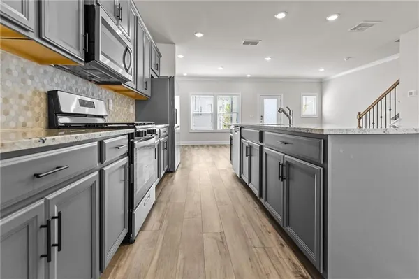 a kitchen with stainless steel appliances granite countertop lots of counter space and a sink