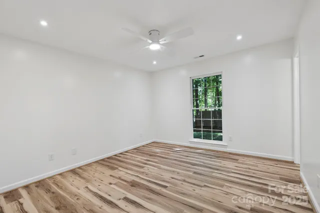 a view of room with hardwood floor and ceiling fan