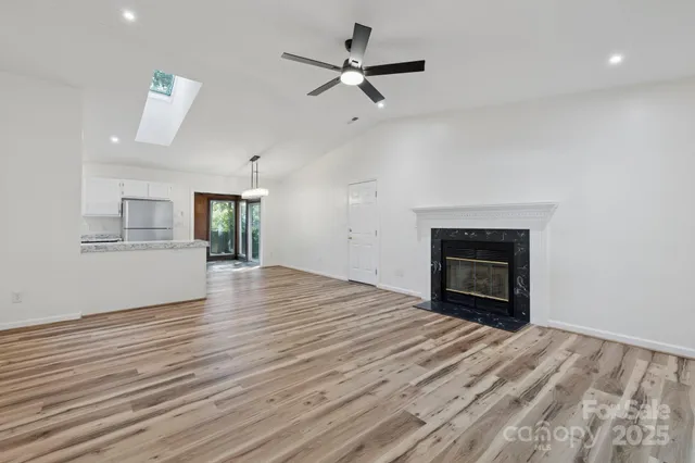 a view of empty room with wooden floor and fireplace