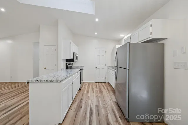 a kitchen with stainless steel appliances granite countertop a refrigerator and a sink