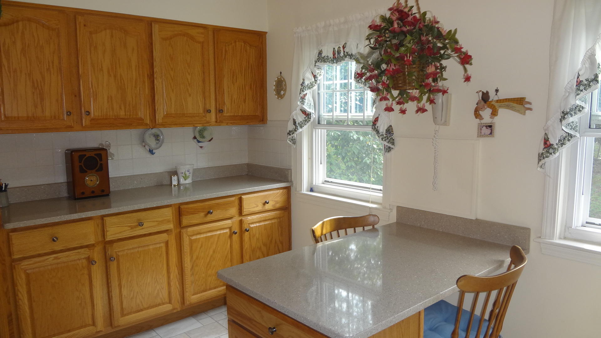 683 Old Post (rt 6a Main St ) Road, Unit 16 Dennis, MA 02638 - Photo 9 of 23 a kitchen with stainless steel appliances granite countertop a sink a microwave a dining table and chairs with wooden floor