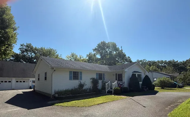 a view of a house with a backyard and trees