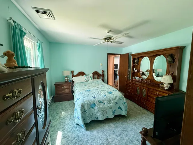 a bedroom with a bed a mirror on dresser and a chandelier
