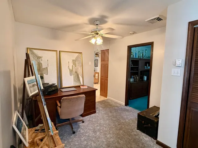 a view of a workspace with furniture and a window
