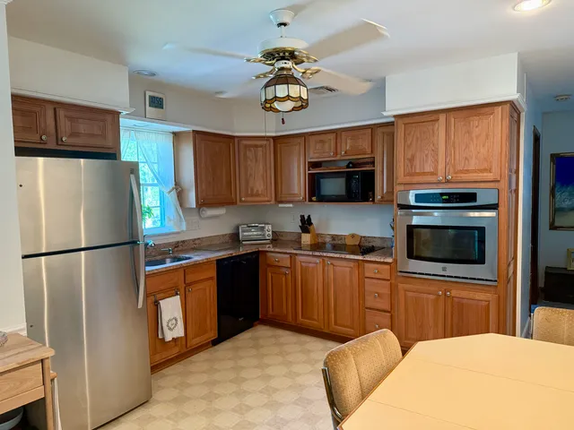 a kitchen with stainless steel appliances granite countertop a refrigerator stove a sink dishwasher and microwave