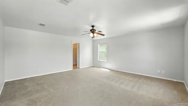 a view of a big room with windows and chandelier fan