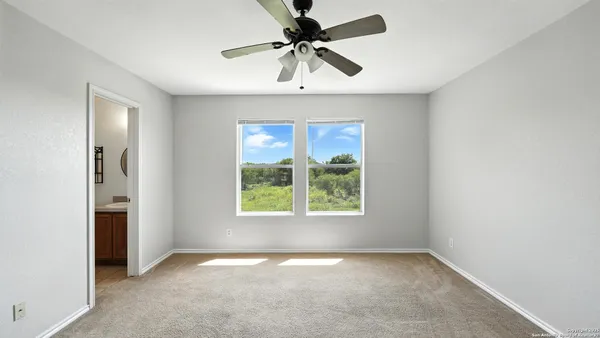an empty room with a window and a fan