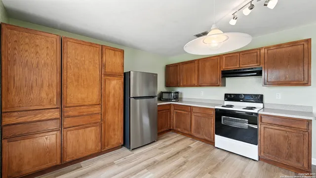 a kitchen with a refrigerator sink and cabinets
