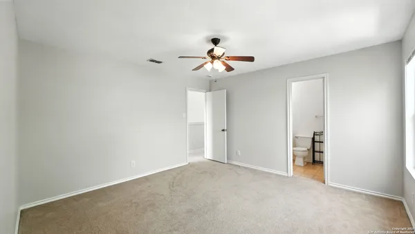 a view of a room with a ceiling fan and a window