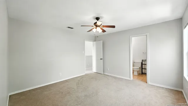 a view of a room with a ceiling fan and a window