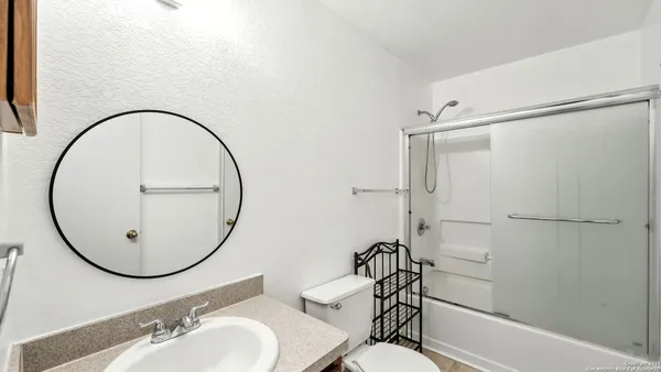 a bathroom with a sink mirror and a shower