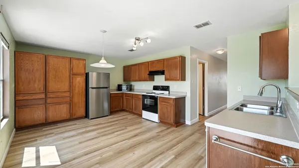 a kitchen with stainless steel appliances granite countertop a refrigerator and a stove top oven