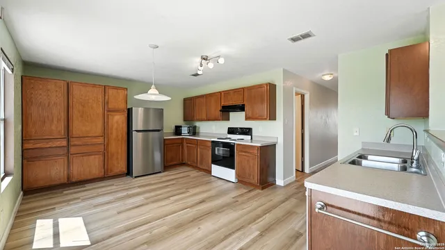 a kitchen with stainless steel appliances granite countertop a refrigerator and a stove top oven