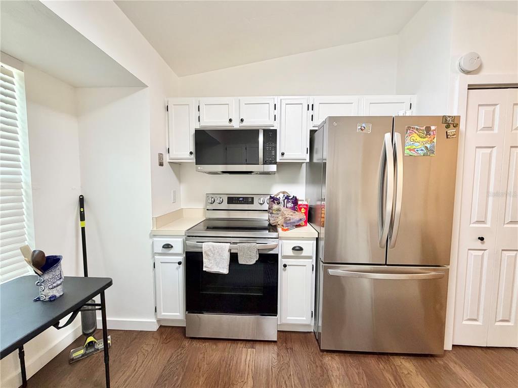 421 Northwest 48th Boulevard Gainesville, FL 32607 - Photo 4 of 26 a kitchen with a refrigerator stove and wooden floor