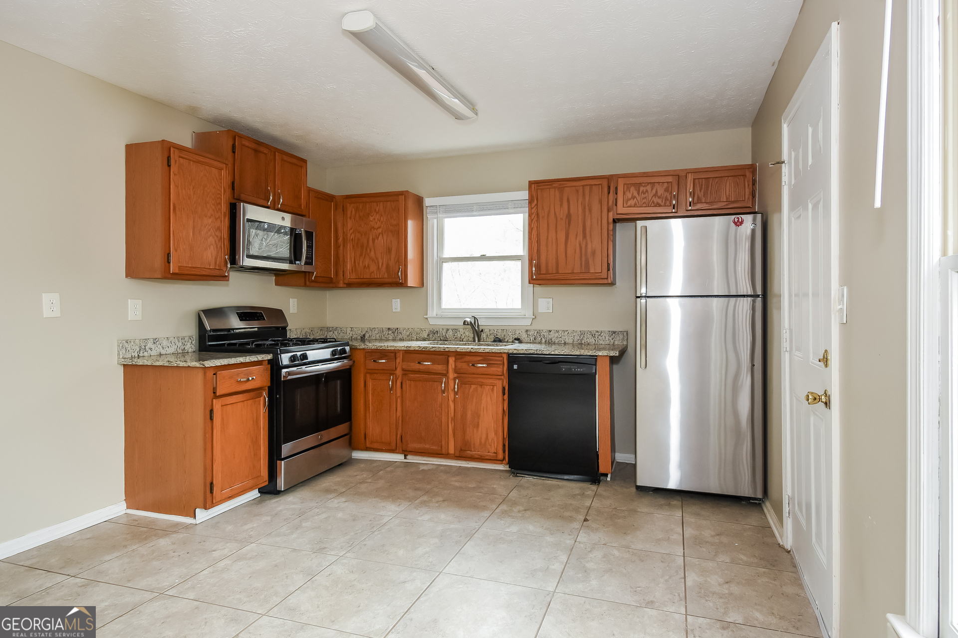 162 Aztec Way Southeast Acworth, GA 30102 - Photo 8 of 17 a kitchen with granite countertop a refrigerator and a stove top oven