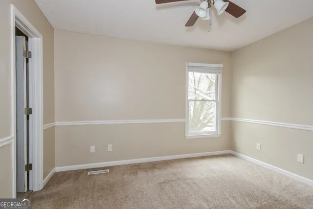 an empty room with a window and a fan