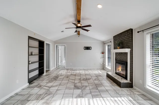 a view of an empty room with a fireplace and a window