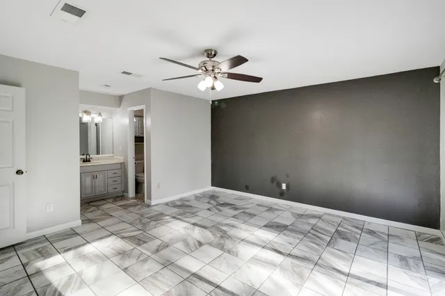 a view of a bedroom with a sink and a chandelier fan