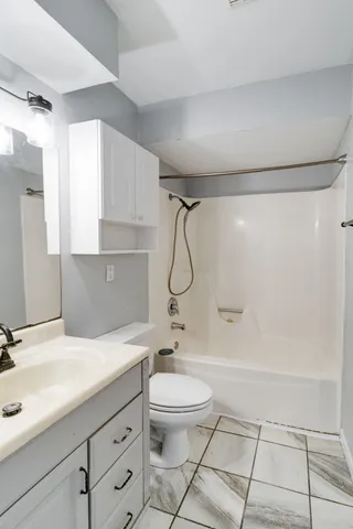a bathroom with a granite countertop sink a toilet and a shower