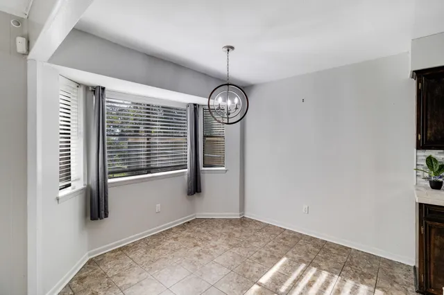 a view of a hallway with windows and chandelier